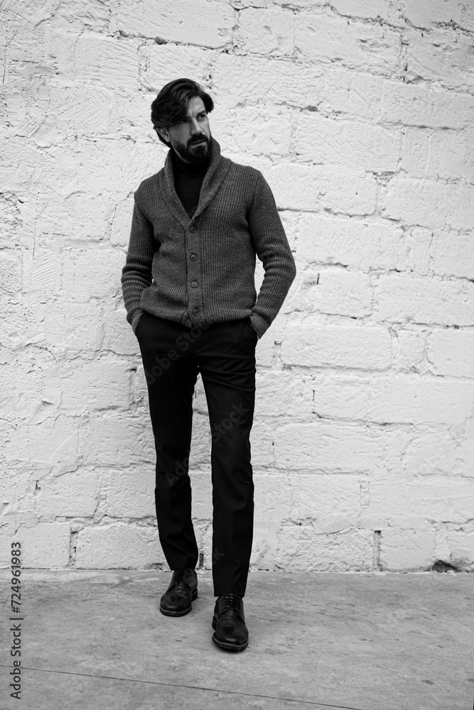 Full length image of a handsome bearded man, looking at the side. Black and white image. Full length image of a handsome bearded man, looking at the side. Black and white image.