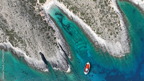 Aerial drone photo of traditional red fishing boat anchored in emelald crystal clear sea caves of Zakynthos island, Ionian, Greece