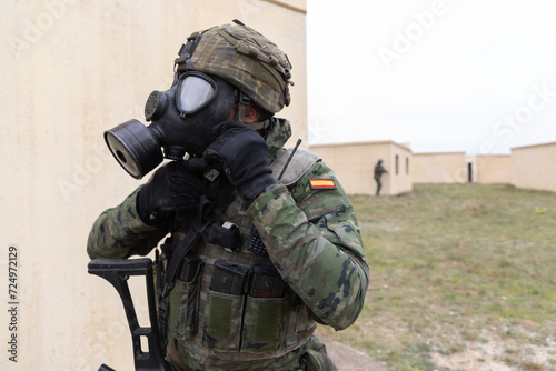 Tableau sur toile Un soldado español se coloca la mascara antigás durante unas maniobras militares