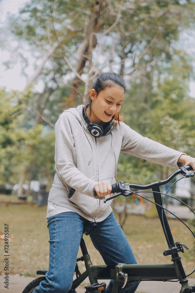 Obraz premium Happy Asian young woman walk and ride bicycle in park, street city her smiling using bike of transportation, ECO friendly, People lifestyle concept.