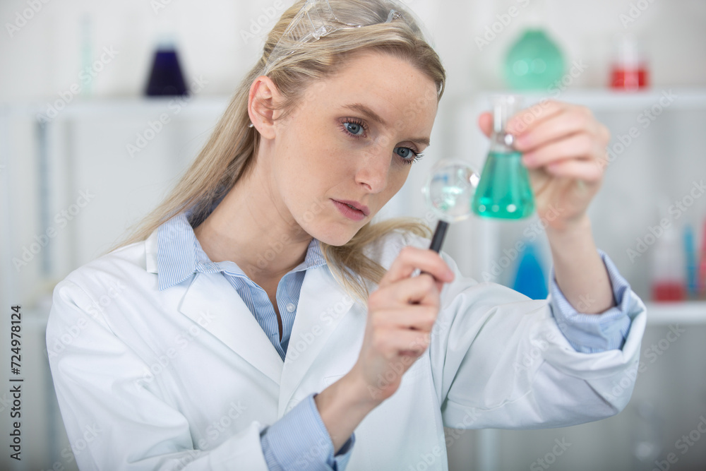 woman holding magnifying glass for analysis test tubes woman holding magnifying glass for analysis test tubes