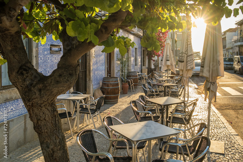 Outdoor cafe on a beautiful street with traditional azulejos Portuguese houses in Tavira photo