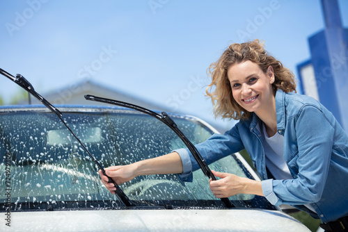 Canvas Print beautiful woman worker washing windshield