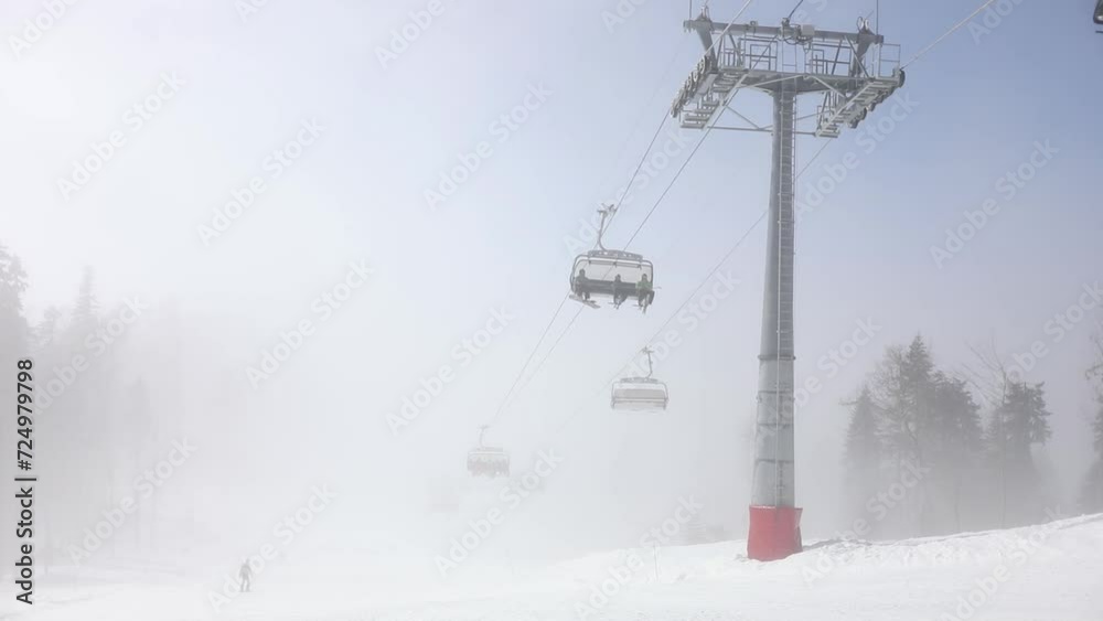 Support with unrecognized people on chairlift in white fog of cloud Support with unrecognized people on chairlift in white fog of cloud