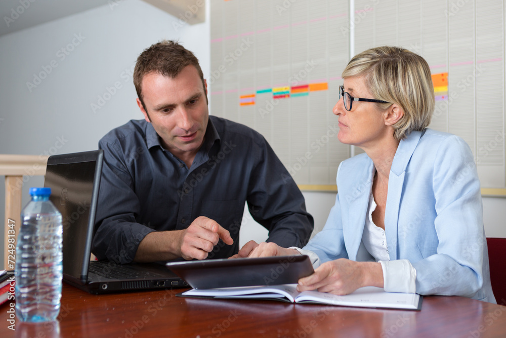 secretary helping boss with tablet in office secretary helping boss with tablet in office