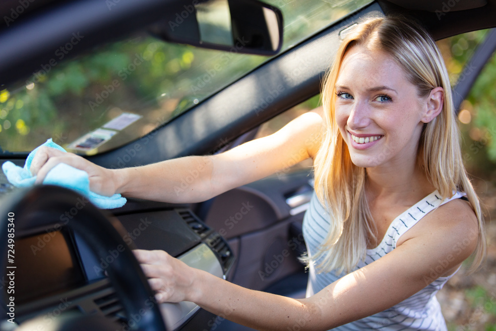 happy woman cleaning her car dashboard happy woman cleaning her car dashboard