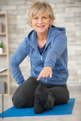senior woman exercising at home © auremar