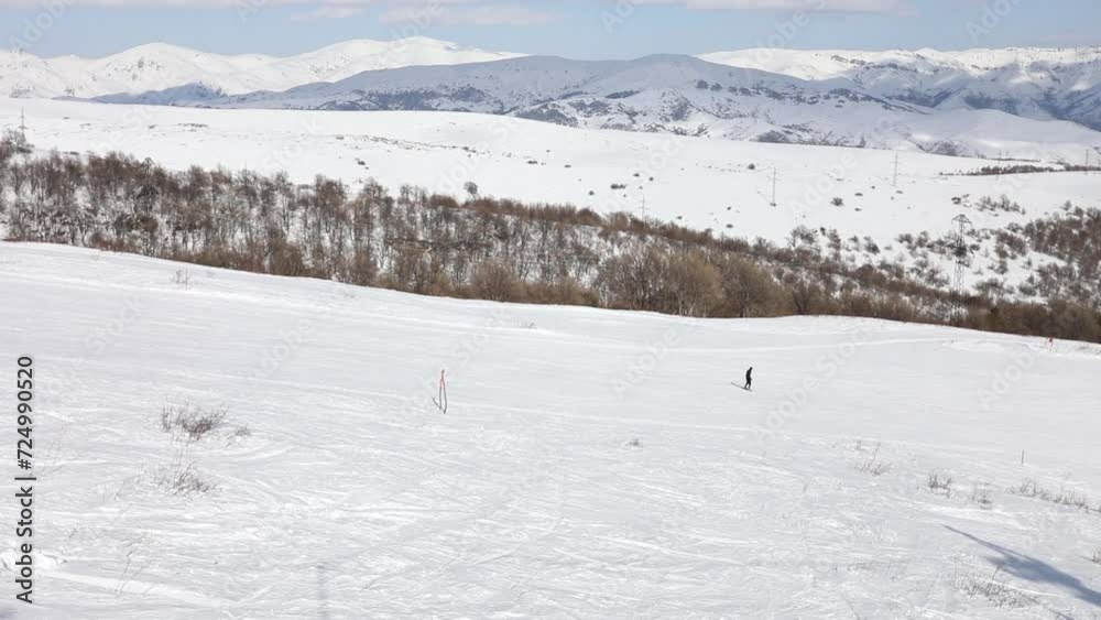 One unrecognized man go down on skis on slope at sunny day in Armenia One unrecognized man go down on skis on slope at sunny day in Armenia