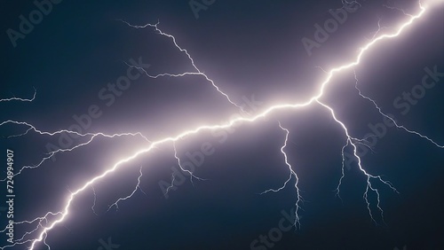 lightning in the night sky A bright white lightning bolt in a dark blue sky  creating a contrast of light and dark.  