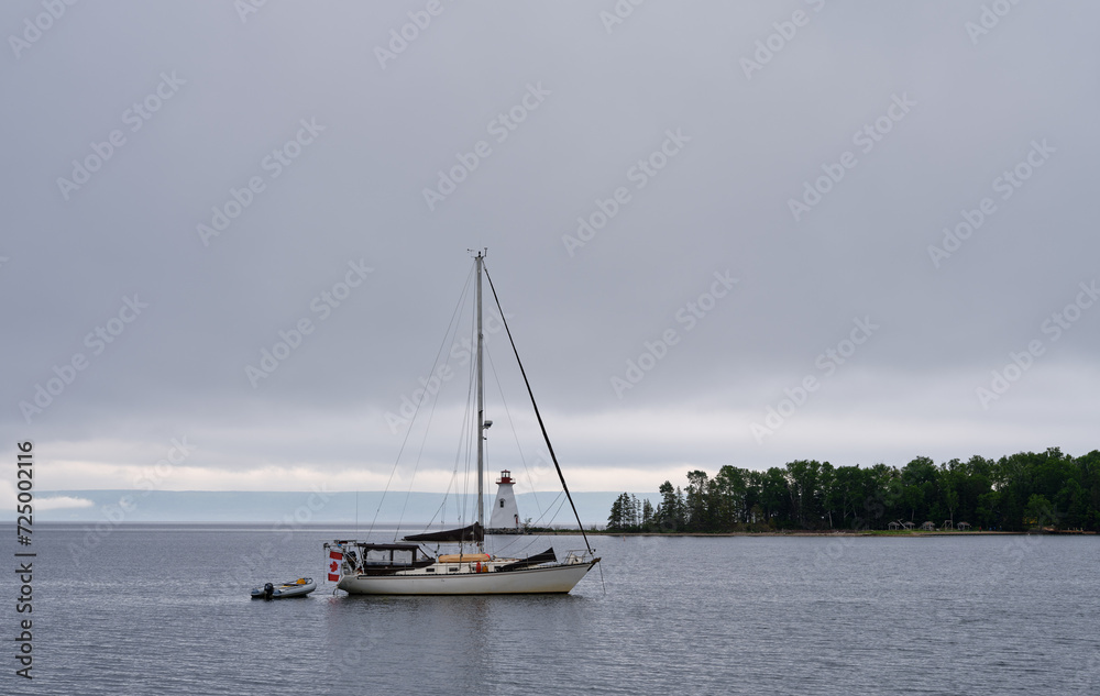 The Lighthouse at St. Annes Harbour on Nova Scotia and a moored sailboat