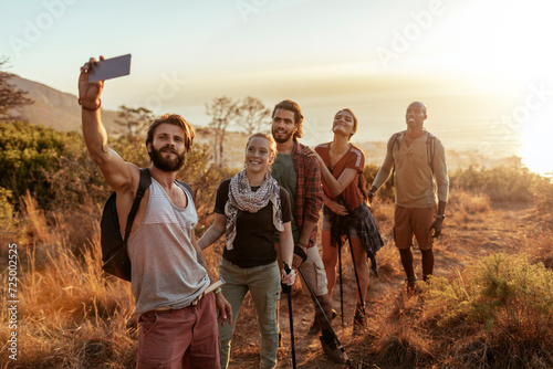 Diverse group of young hikers taking a selfie with smartphone in south africa photo