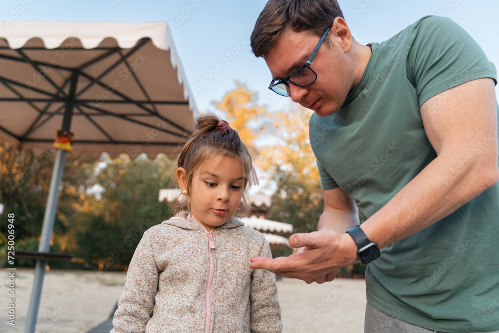 Fototapeta premium Father with child girl playing on the riverside, happy modern involved fatherhood.