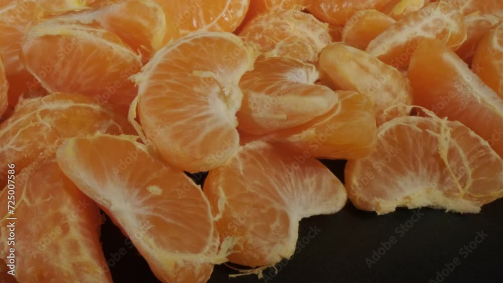 Peeled tangerines on a black background. Close-up. Peeled tangerines on a black background. Close-up.