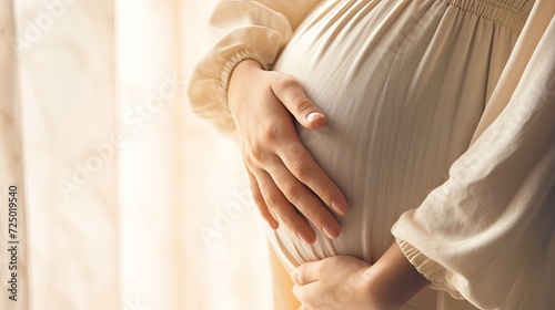beauty of pregnancy with a close-up photo of a woman's hand touching her full belly.