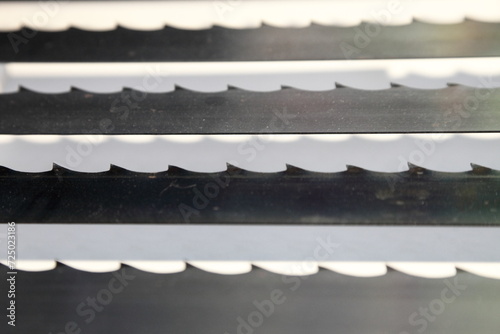 Band-saw blades for wood sawing closeup. Woodworking machine equipment photo