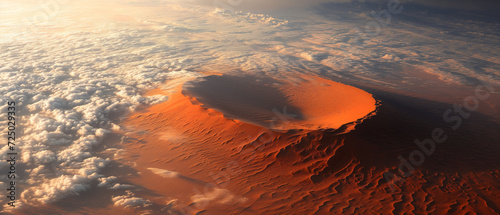Reddishbrown desert sand dune is surrounded by clouds photo