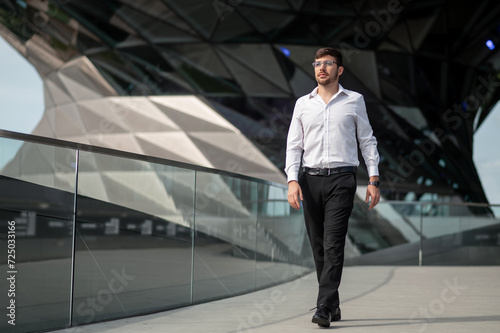 Good-looking young man in elegant outfit on urban background