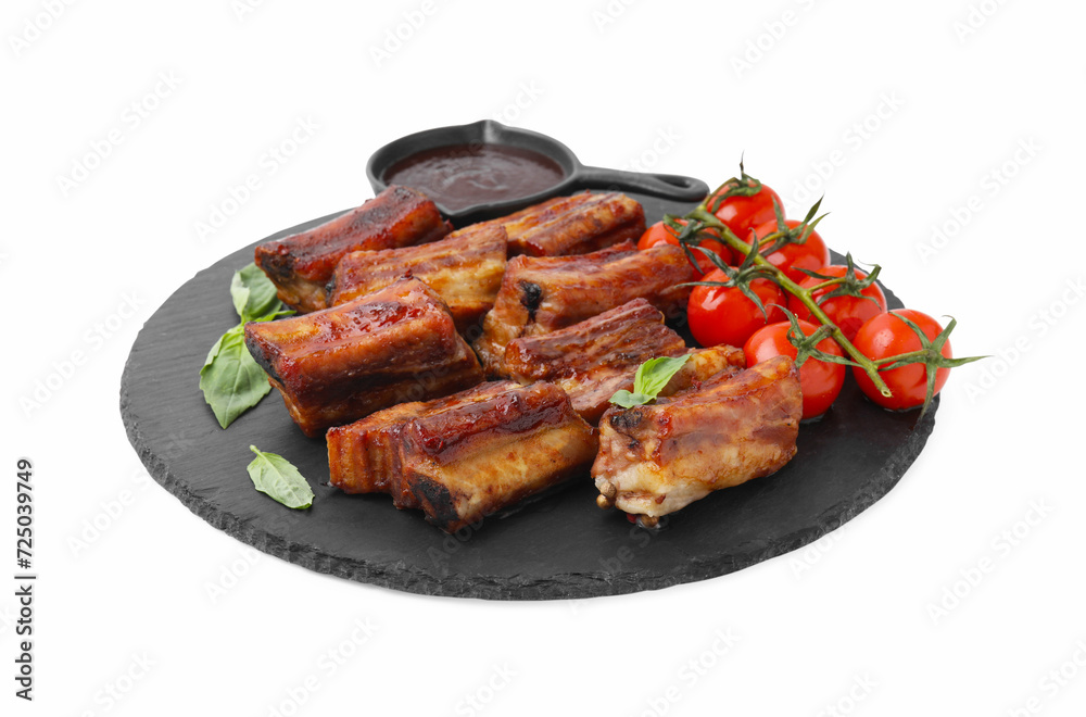 Tasty roasted pork ribs, basil, sauce and tomatoes isolated on white Tasty roasted pork ribs, basil, sauce and tomatoes isolated on white