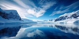 A serene winter wonderland of pristine snow, majestic mountains, and a tranquil glacial lake reflecting the clear blue sky