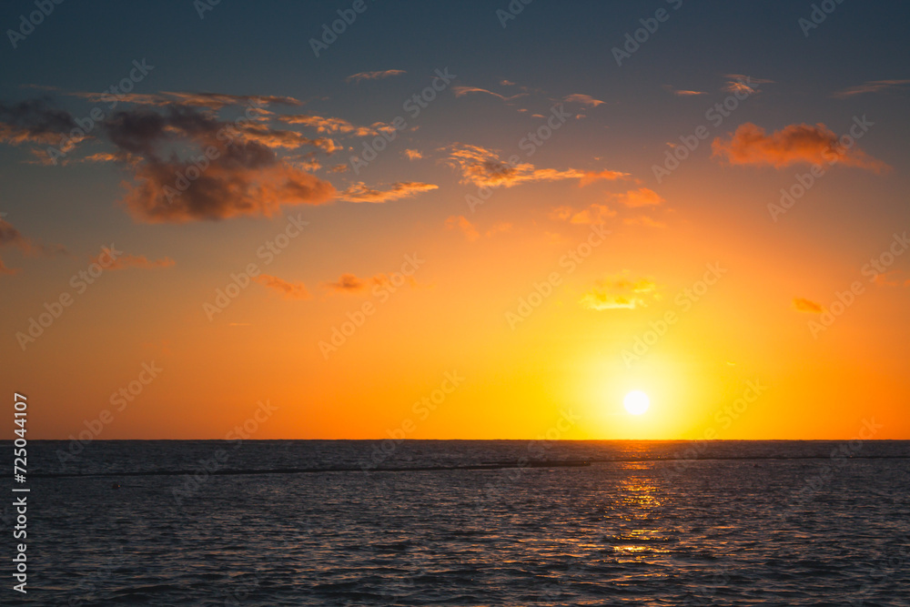 Beautiful sunrise at sea. Dawn on the Atlantic ocean. The sun is reflected in the sea. Palm trees against the background of the rising sun. Tropical sunrise. Dominican Republic