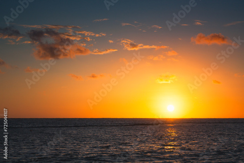 Beautiful sunrise at sea. Dawn on the Atlantic ocean. The sun is reflected in the sea. Palm trees against the background of the rising sun. Tropical sunrise. Dominican Republic
