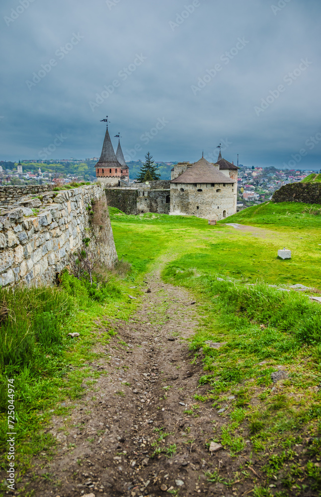 Old Kamianets-Podilskyi Castle under a cloudy grey sky. The fortress located among the picturesque nature in the historic city of Kamianets-Podilskyi, Ukraine