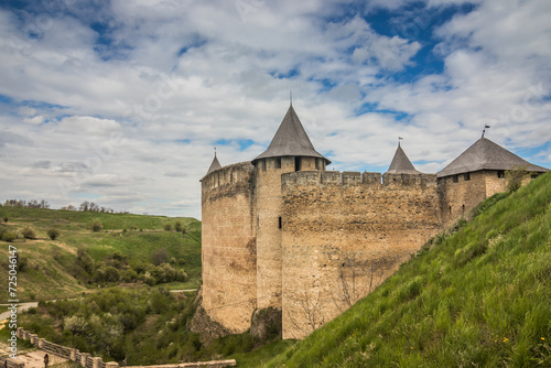 View of old castle Hotin near the river. Khotyn Fortress - medieval castle on yellow autumn hills. Ukraine, Eastern Europe. The architecture of the Middle Ages in our time.