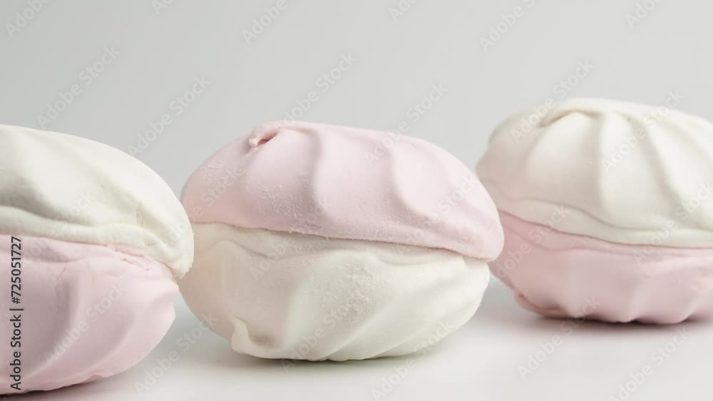 White and pink meringue cookies rotate on a white background. Meringue cookies close-up. White and pink meringue cookies rotate on a white background. Meringue cookies close-up.