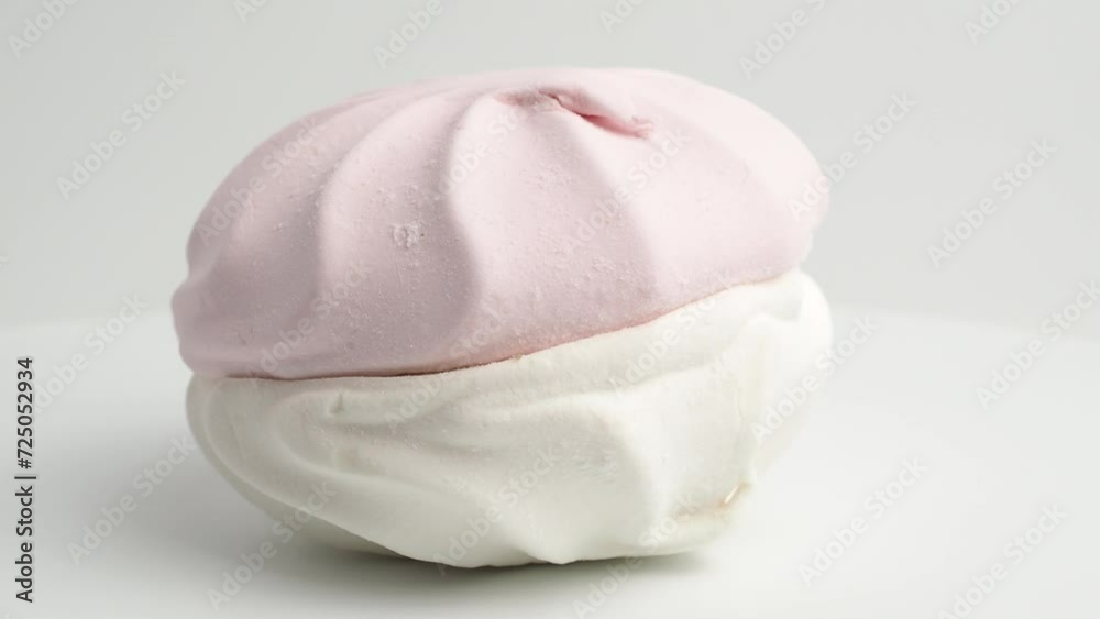 White and pink meringue cookies rotate on a white background. Meringue cookies close-up. White and pink meringue cookies rotate on a white background. Meringue cookies close-up.