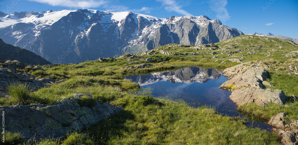 reflet des glaciers de la Meije sur un lac du plateau d'Emparis au refuge des Mouterres dans les Alpes en été	