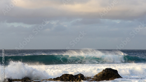 Waves rolling in over volcanic rock in Puert de las Nieves, Gran Canaria, Spain photo