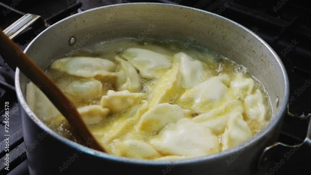 Dumplings and dumplings are boiled in a pan with spices and stirred with a spatula Dumplings and dumplings are boiled in a pan with spices and stirred with a spatula