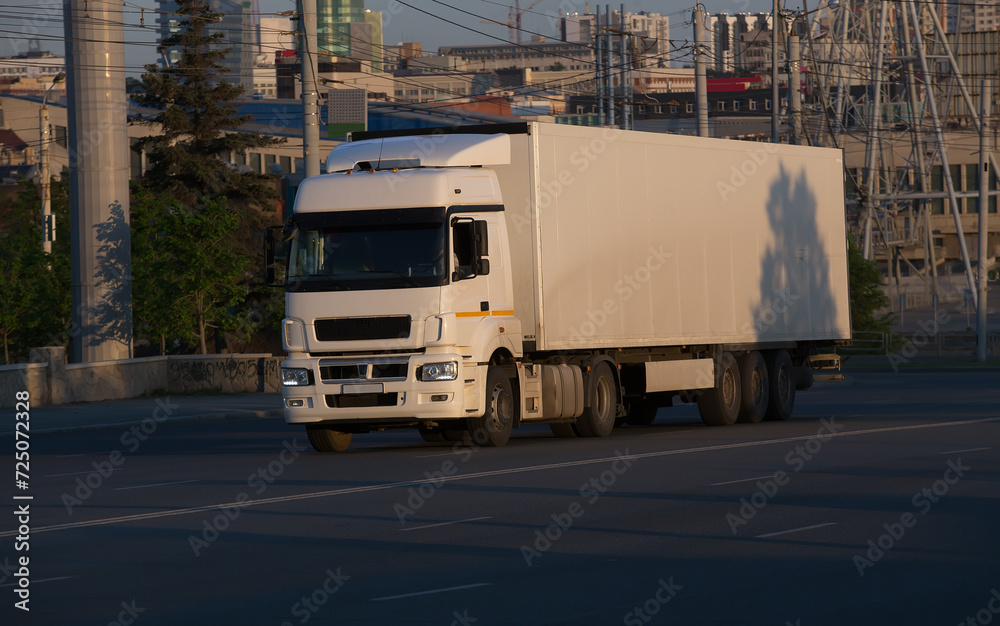 Truck moves along the street against the background of the city