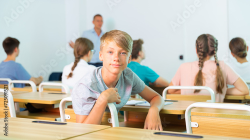 Portrait of young guy student in audience, looking at the camera