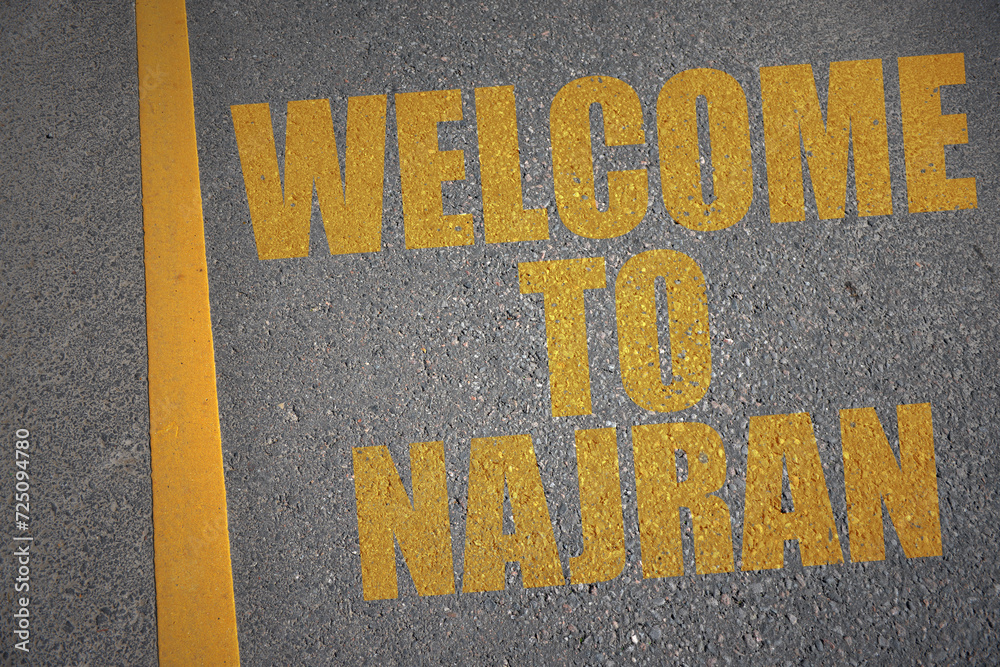 asphalt road with text welcome to Najran near yellow line.