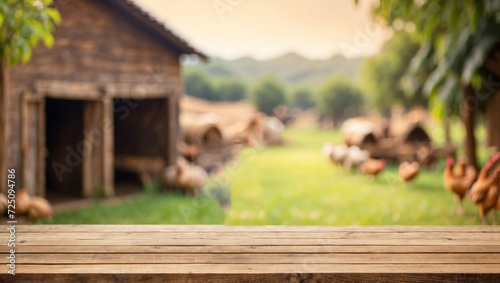 Empty wooden table for product display with blurry chicken farm background photo