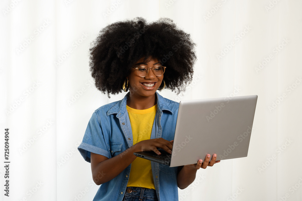 Woman holding laptop and typing on keyboard, looking at laptop, black woman on white background Woman holding laptop and typing on keyboard, looking at laptop, black woman on white background