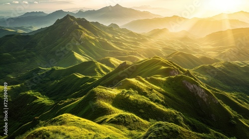 a green mountains with sun shining through the mountains photo