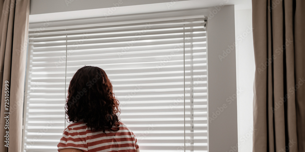Fototapeta premium Woman Looking Out of Window Blinds