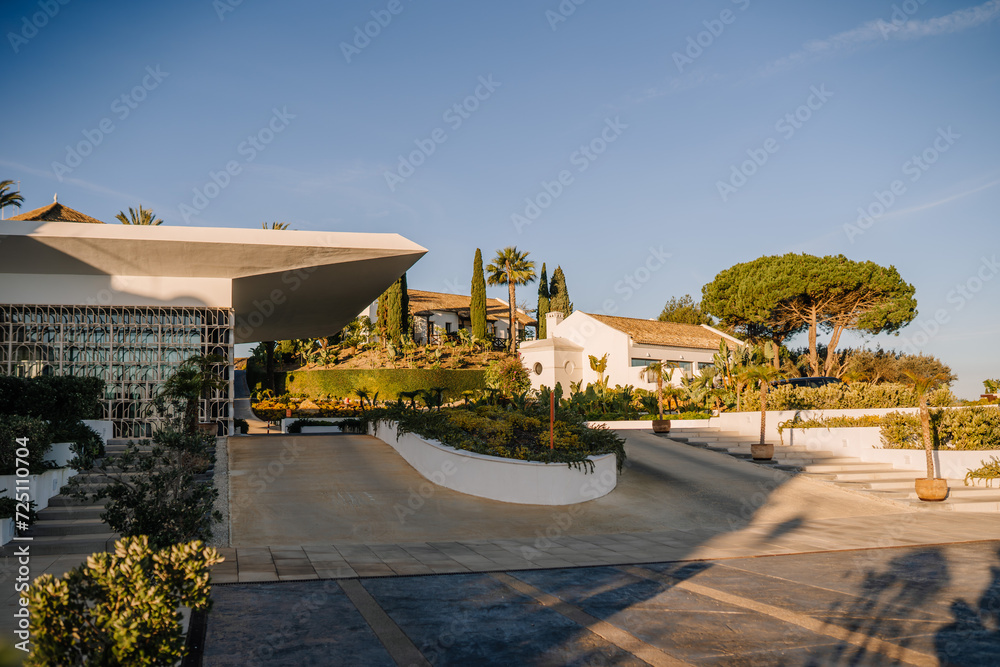 Sotogrante, Spain - January 25, 2024 - Modern resort architecture with terraced gardens under a clear sky at golden hour