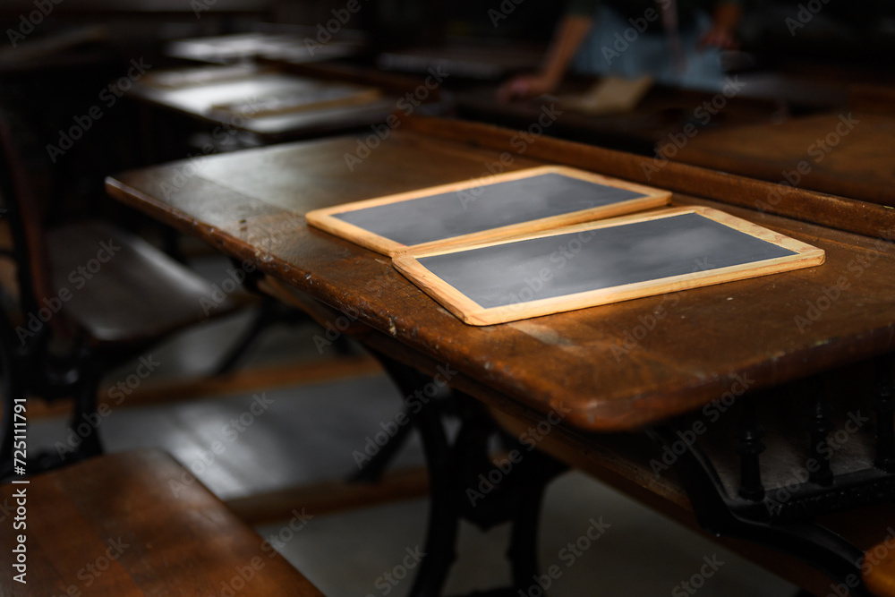 Slates on Wooden Desk Schoolteacher in Background