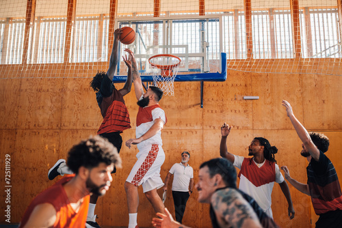 Interracial basketball player dunking the ball on his training.
