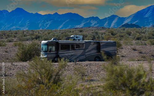 Rv motorhomes parked on state land under mountain and blue cloudy sky