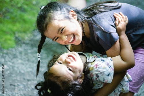 Two happy young Maori sisters playing and posing for the camera.