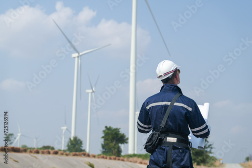 engineers working in fieldwork outdoor. Workers walking and inspect construction and machine around project site. Wind turbine electrical of clean resource enerdy and environment sustainable.