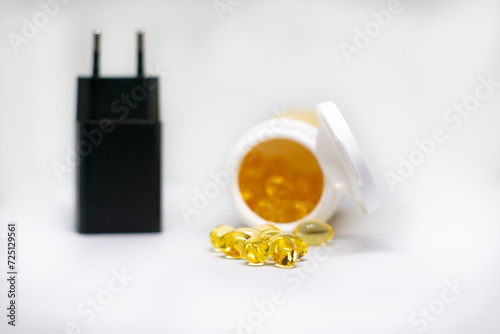 Omega 3 vitamins, oil fish supplements isolated on a  background with an enlargment glass. photo