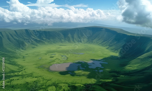 Elevated view of floor of Ngorongoro Crater from the southern edge of the crater. Looking toward Lerai Forest and the alkaline crater lake, Lake Magadi, with clouds covering the rim on other side. © STORYTELLER