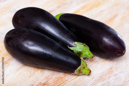 Closeup of fresh eggplants on wooden surface. Healthy vegetarian ingredient