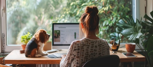 Young female freelancer working from home with her dog, dressed for summer. photo