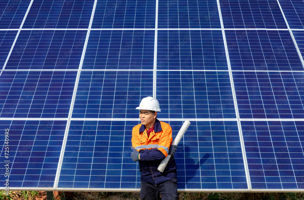 Confident male professional engineer working installing large solar panel system. Standing with arms crossed and looking away. Alternative energy technician work for the future. Confident male professional engineer working installing large solar panel system. Standing with arms crossed and looking away. Alternative energy technician work for the future.